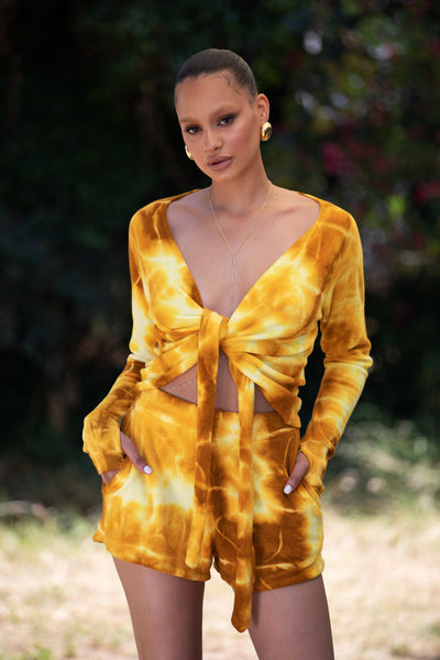 Model wearing Mustard Lightning Malibu Shorts, displaying the vibrant tie-dye pattern and comfortable fit.