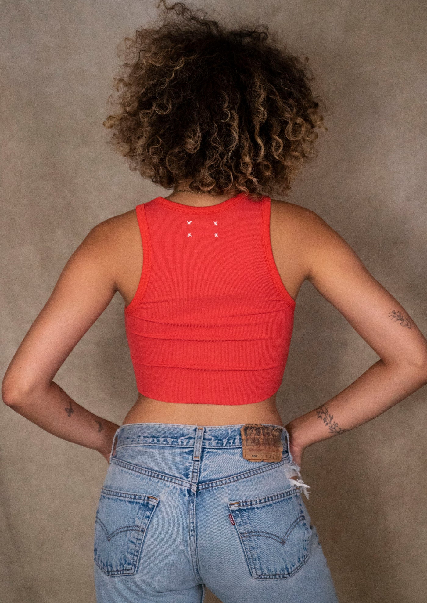 Backside view of the Fire Red Classic Crop Tank on a model, accentuating the tank's chic and snug fit.