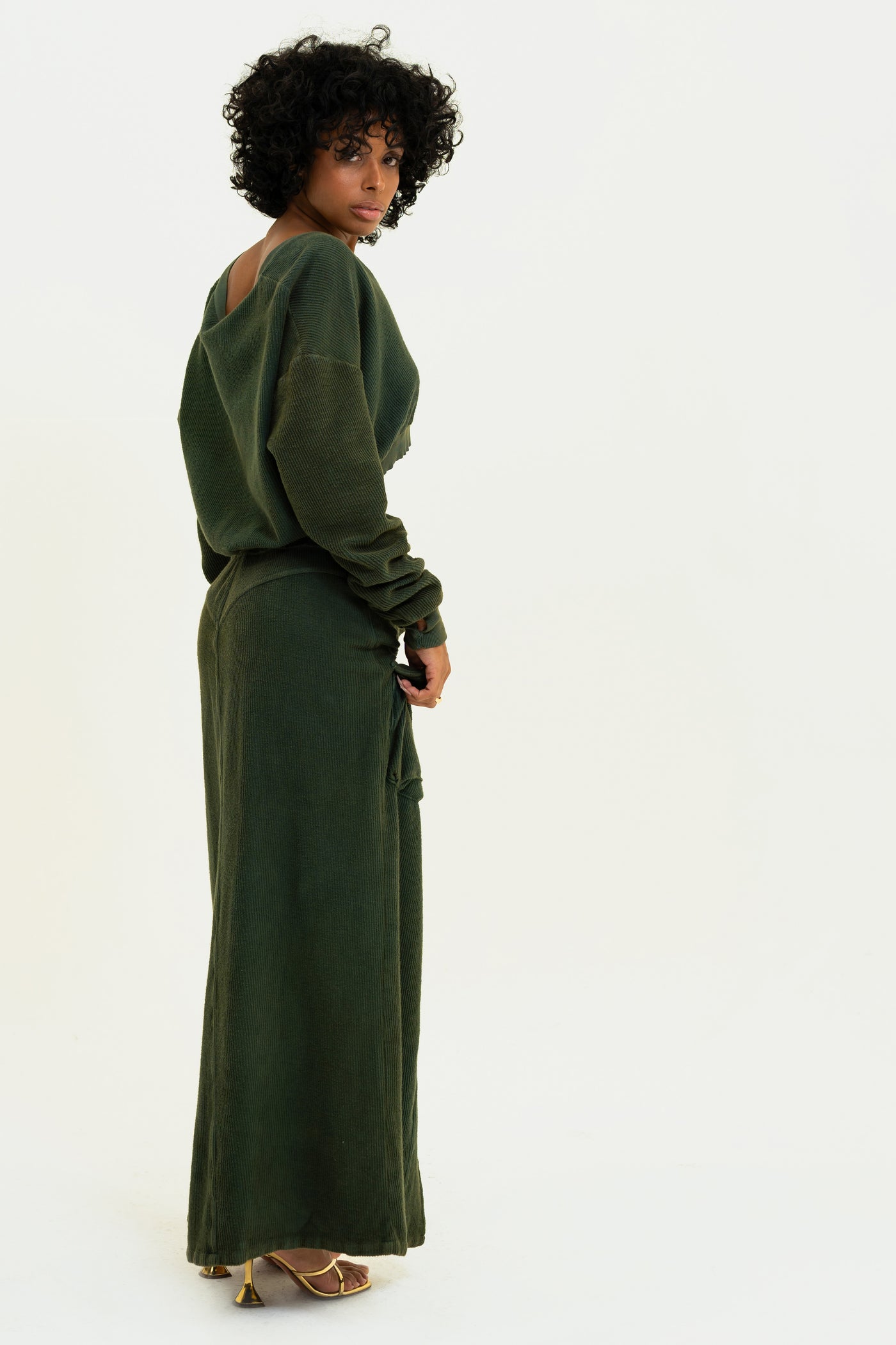 Model showcasing the back of the Aspen set featuring the pullover and pants in the color Olive.