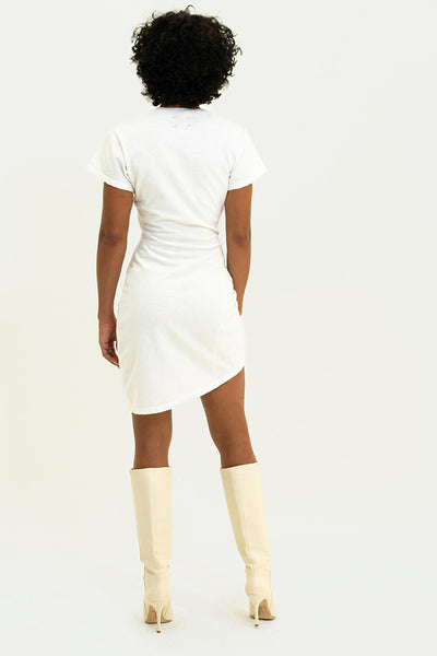 White Luna Dress on a model, showcasing the dramatic asymmetrical hemline and the dresses sleek silhouette.