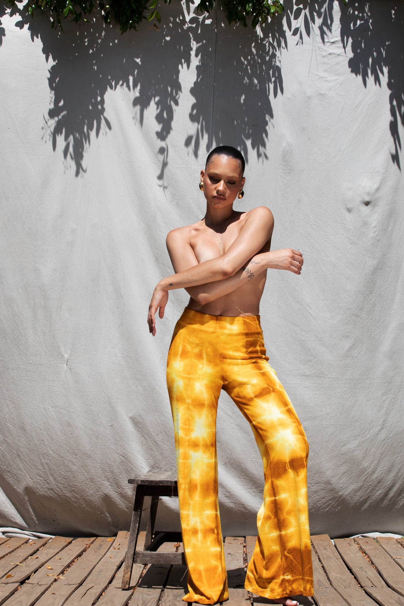 Mustard Lightning Malibu Pants on model, featuring vibrant tie-dye, soft fabric, and comfy elastic waistband.