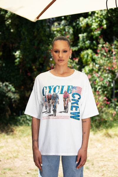 Model standing amidst bushes, wearing the Cycle Crew Embellished Tee | Made in the USA