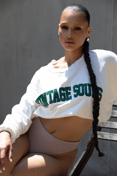 Model in Crystal Varsity Bungee Crop showcasing comfortable fit, thumbholes, and crystal logo.