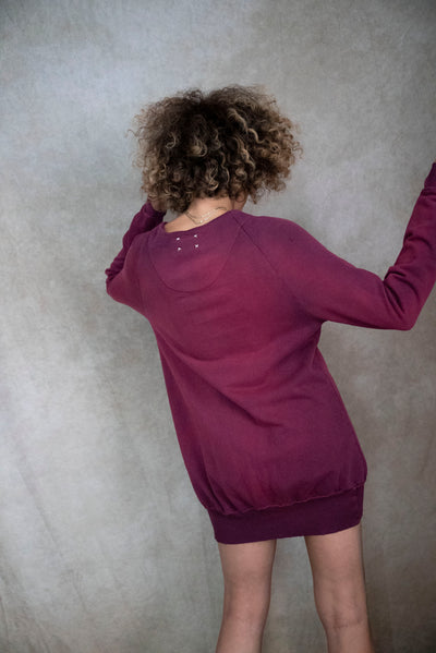 Model showcasing the back of the Vintage Souls Jewel Sweater Dress in Washed Eggplant